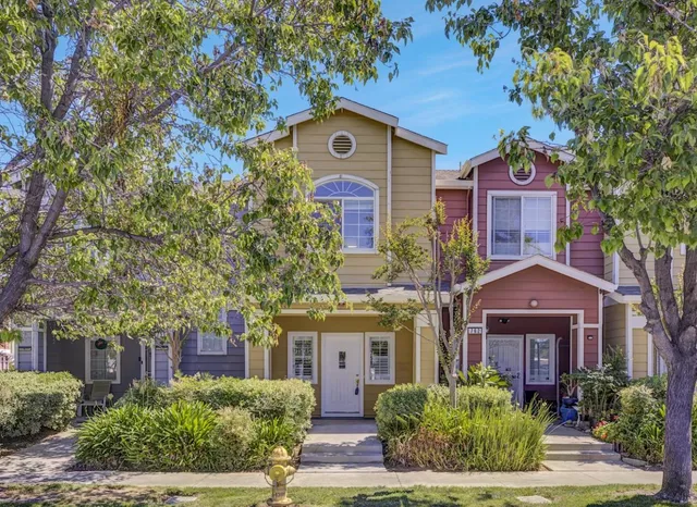 front view of house with a tree in front of it