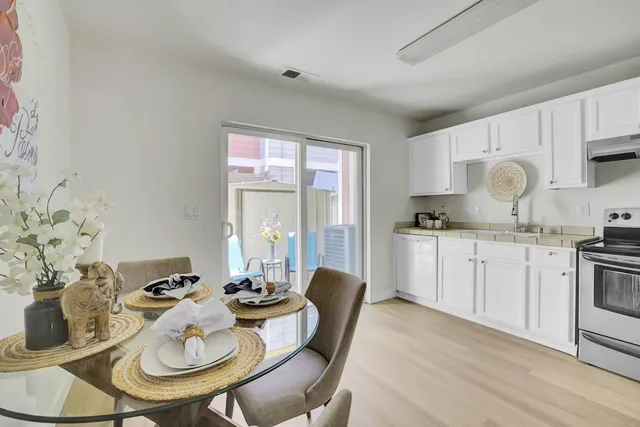a kitchen with granite countertop white cabinets and stainless steel appliances