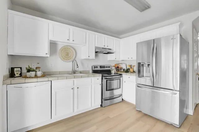 a kitchen with cabinets stainless steel appliances and a counter space