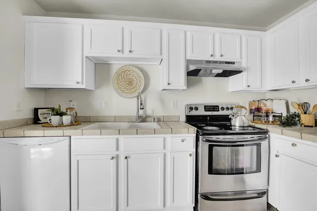 a kitchen with stainless steel appliances granite countertop a sink a stove and cabinets