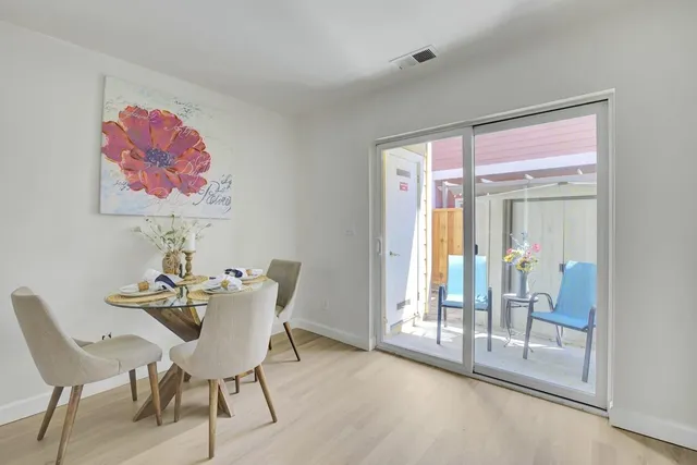 a view of a dining room with furniture and large windows
