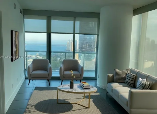a living room with furniture and a floor to ceiling window
