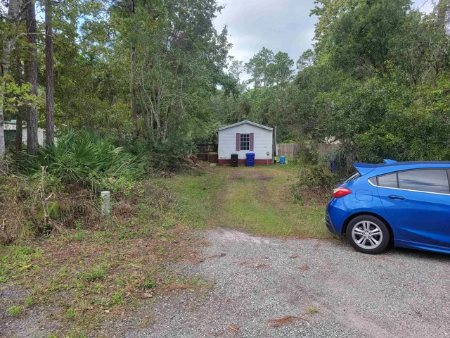 a backyard of a house with table and chairs