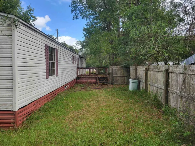 a view of a small house with a yard