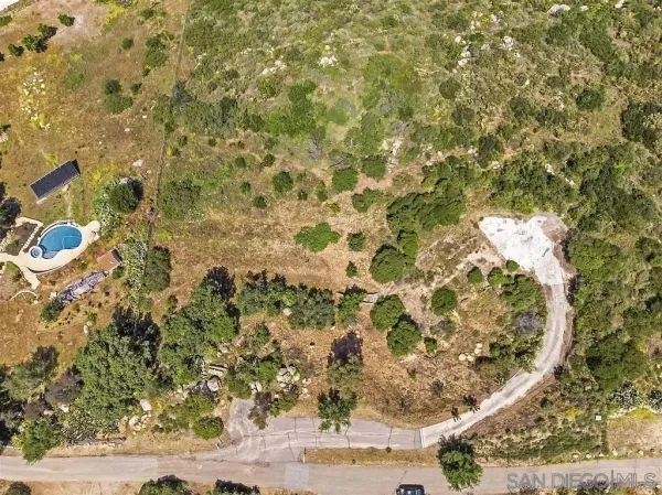 a view of a dry yard with wooden fence