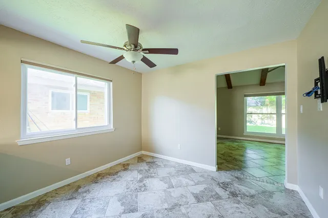 an empty room with fan and windows