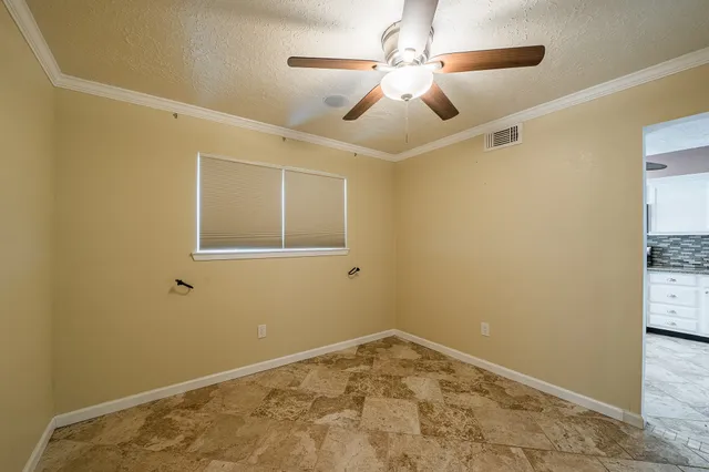 a view of a room with a ceiling fan and a window