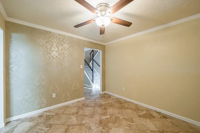 an empty room with a ceiling fan and carpet
