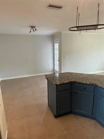 a bathroom with a granite countertop sink and washing machine
