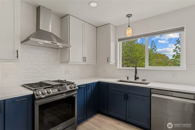 a kitchen with granite countertop wooden floors a refrigerator and cabinets