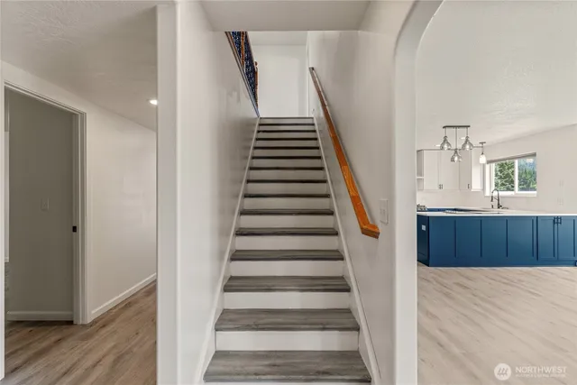 an empty room with wooden floor closet and windows