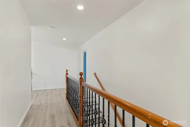 a view of an empty room with closet and wooden floor