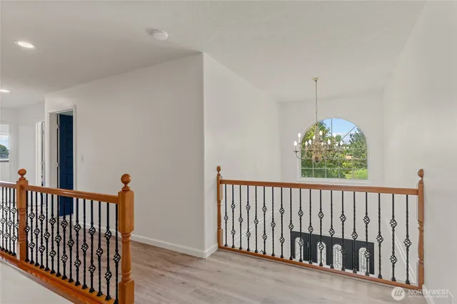 an empty room with windows and a ceiling fan
