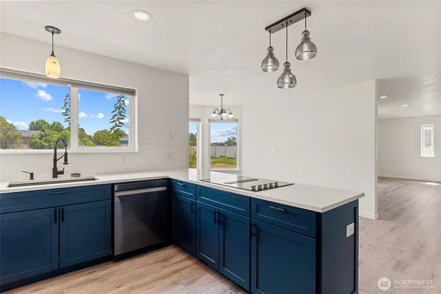 a kitchen with stainless steel appliances a sink a stove and a window