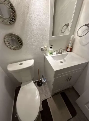 a bathroom with a toilet sink and mirror