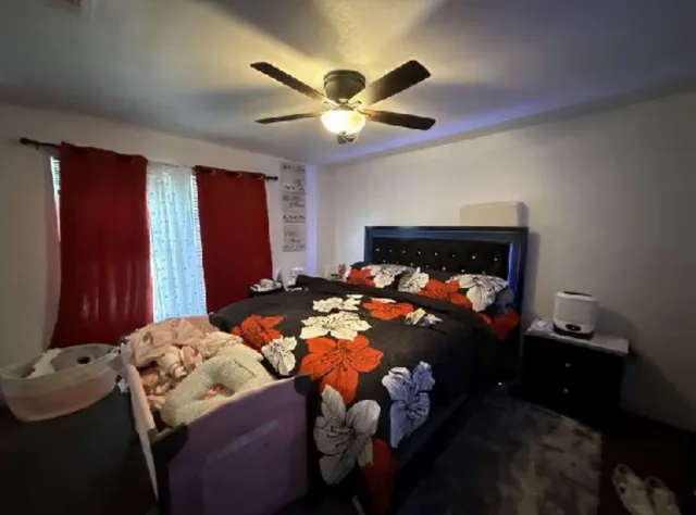a bed room with a bed and a ceiling fan