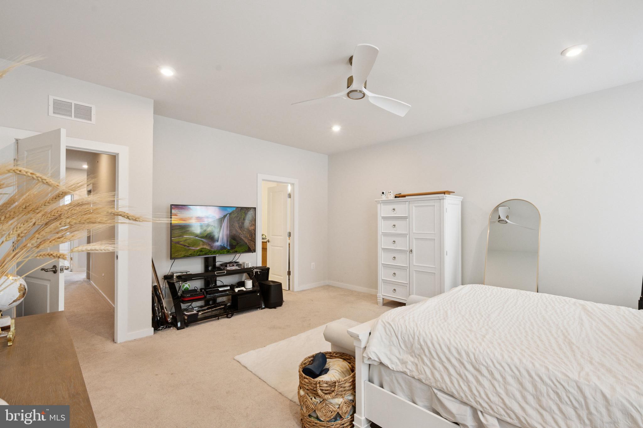 13506 Innovation Station Loop, Unit 2B Herndon, VA 20171 - Photo 27 of 32 a bedroom with a bed and a flat tv screen on dresser