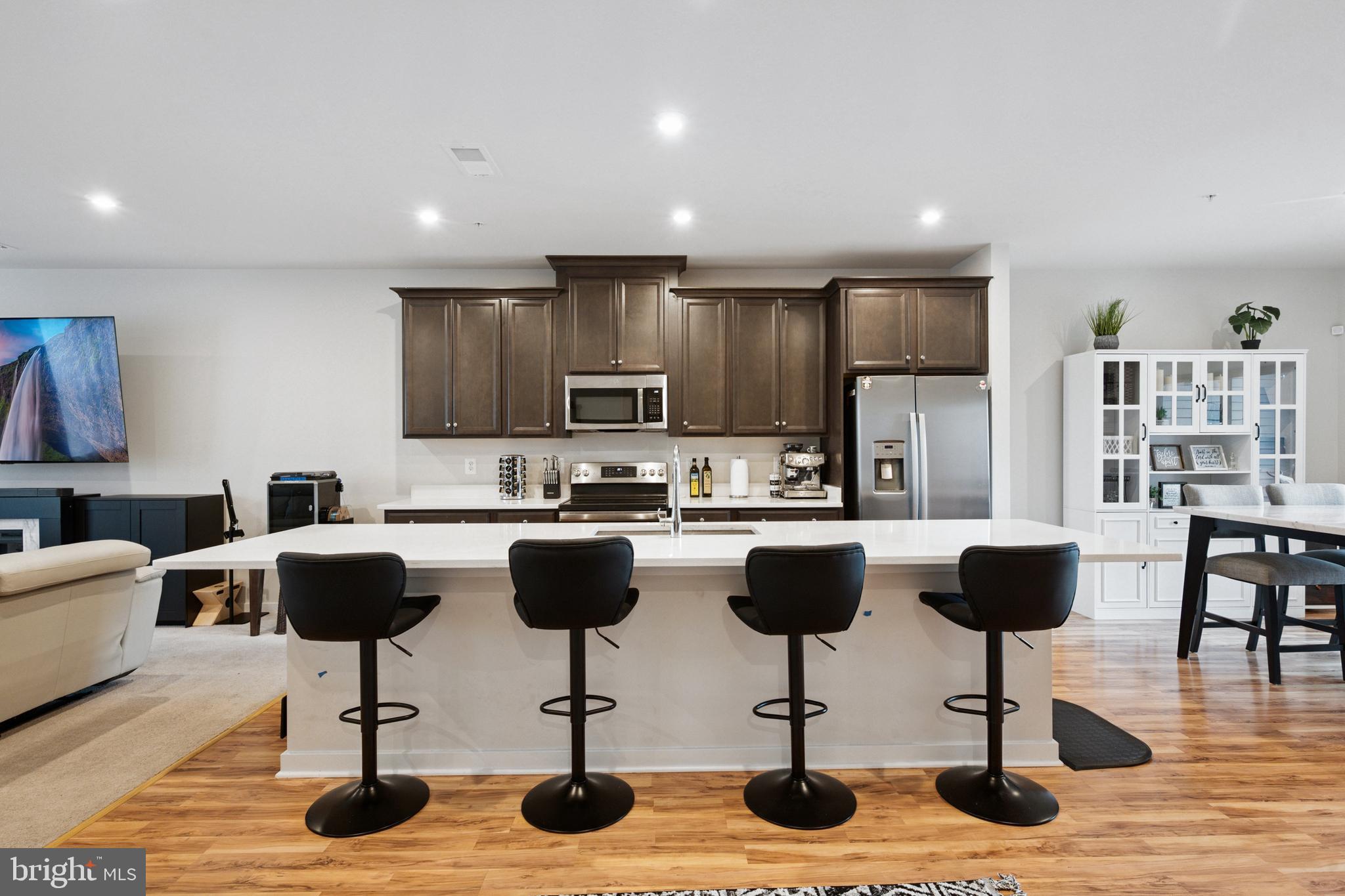 13506 Innovation Station Loop, Unit 2B Herndon, VA 20171 - Photo 4 of 32 a view of kitchen with granite countertop kitchen island stainless steel appliances refrigerator stove dining table and chairs