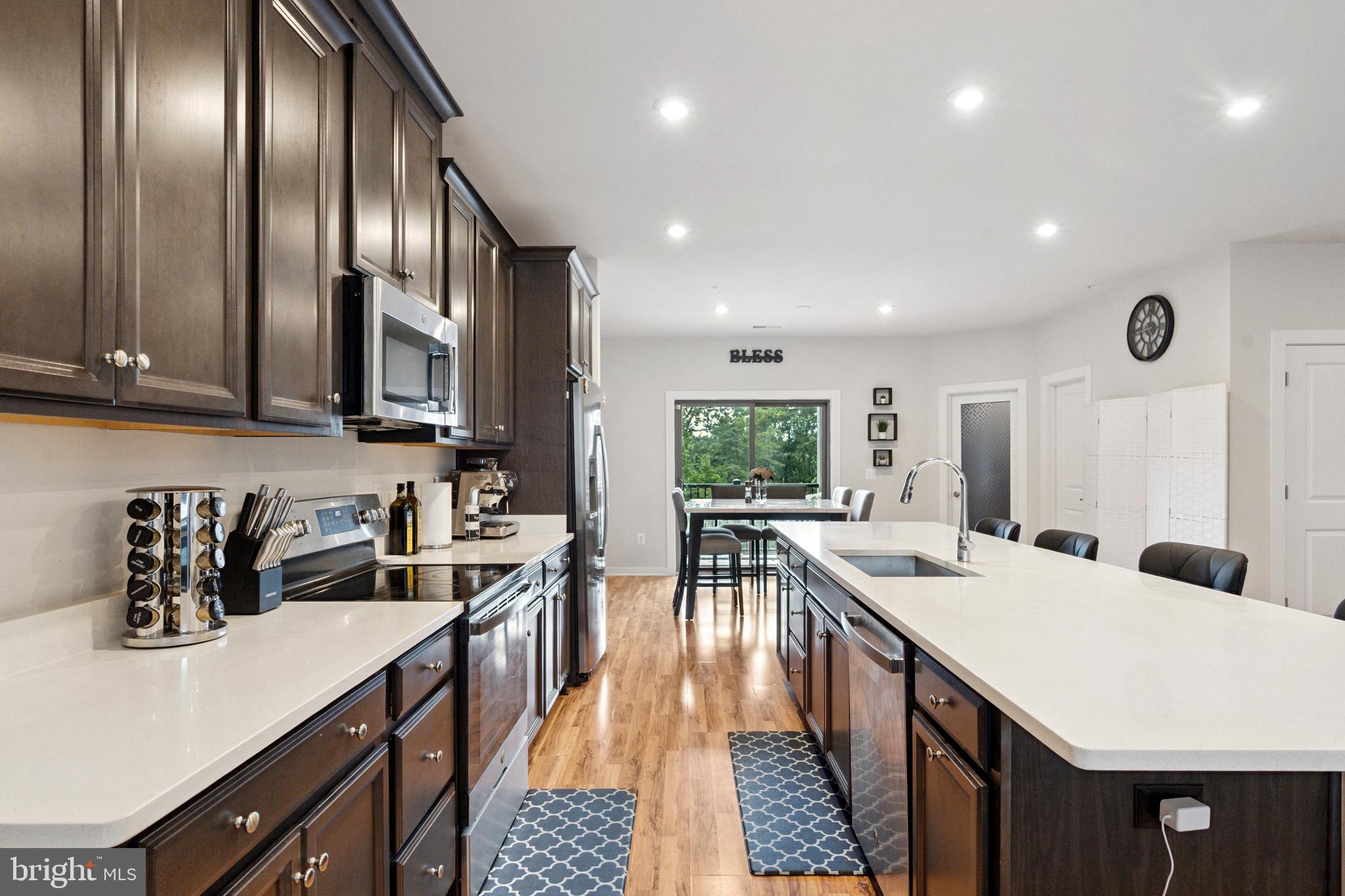 13506 Innovation Station Loop, Unit 2B Herndon, VA 20171 - Photo 7 of 32 a kitchen with stainless steel appliances granite countertop a sink a stove top oven a counter space and cabinets