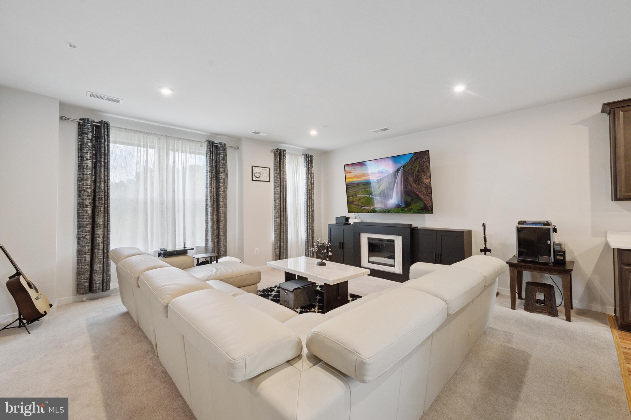 13506 Innovation Station Loop, Unit 2B Herndon, VA 20171 - Photo 9 of 32 a living room with furniture a fireplace and a flat screen tv
