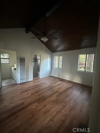 a view of an empty room and window and wooden floor