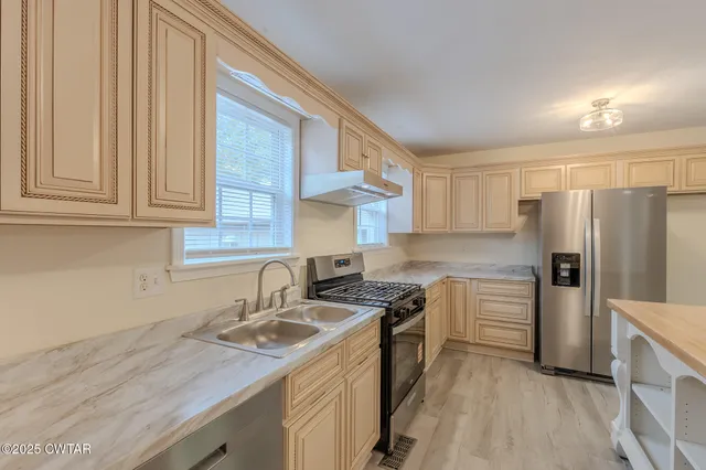 a kitchen with stainless steel appliances granite countertop a sink stove and refrigerator