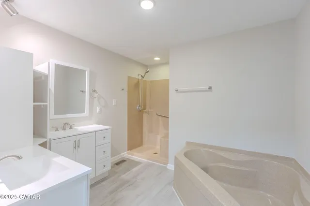 a bathroom with a tub sink and mirror