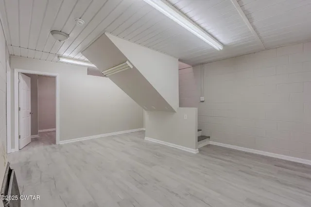 an empty room with wooden floor and entryway
