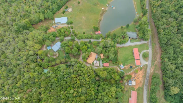 an aerial view of a house with a yard and lake view