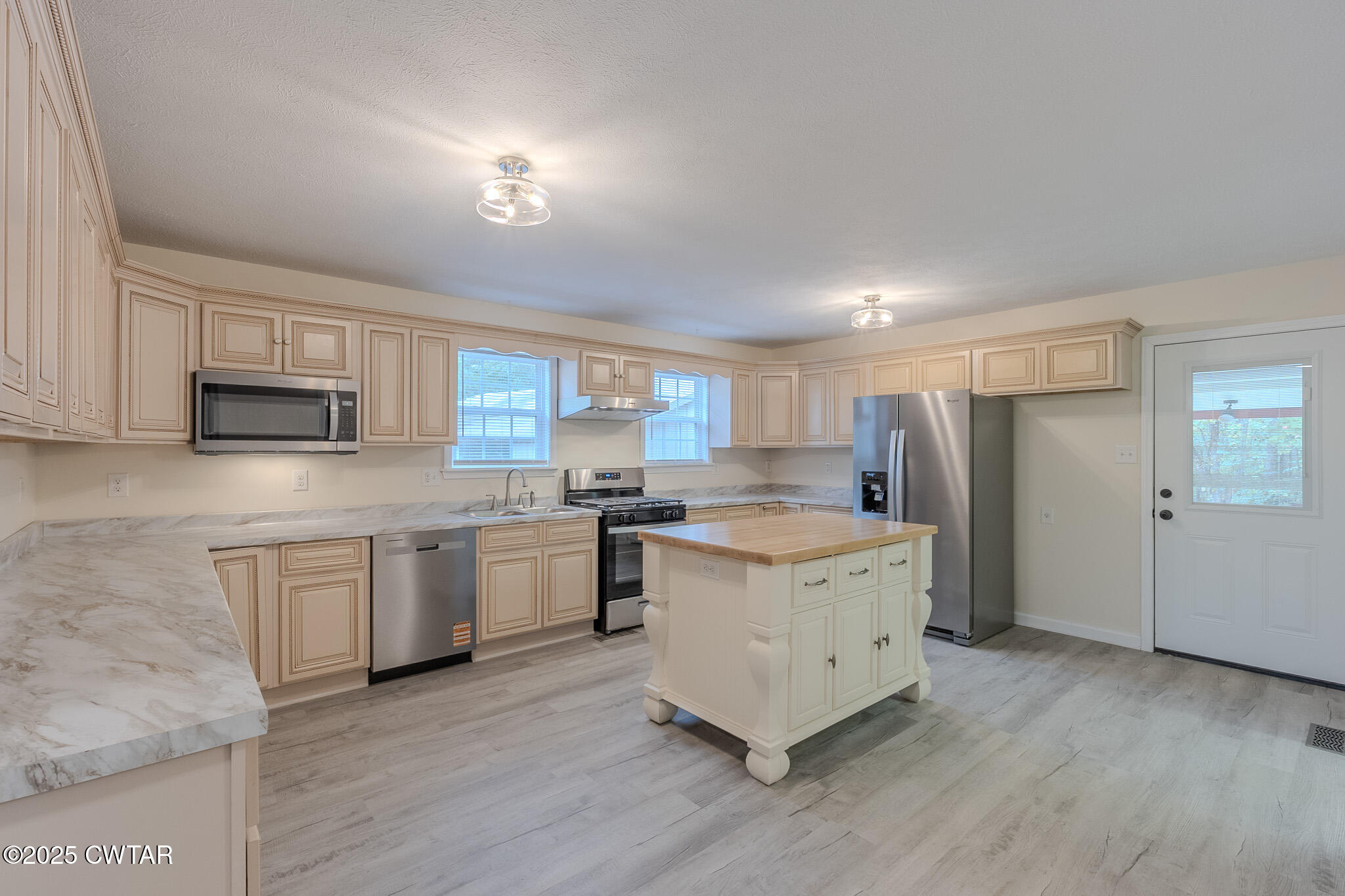 2850 Jeanette Holladay Road Parsons, TN 38363 - Photo 10 of 40 a kitchen with stainless steel appliances granite countertop a stove a sink dishwasher and a refrigerator with white cabinets