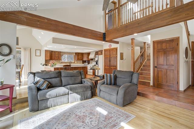 4385 Sandstone Road Monument, CO 80132 - Photo 12 of 50 Living room featuring stairway, light wood finished floors, recessed lighting, and high vaulted ceiling