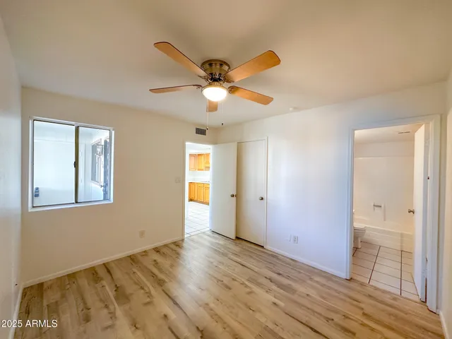a view of an empty room and window and wooden floor