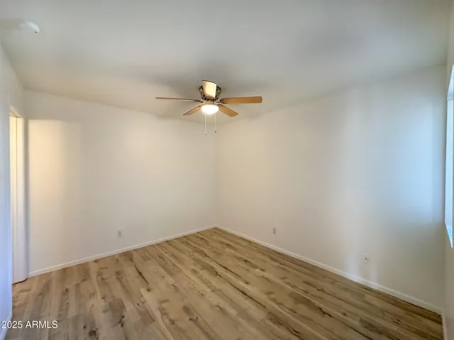 a view of a room with wooden floor and a ceiling fan