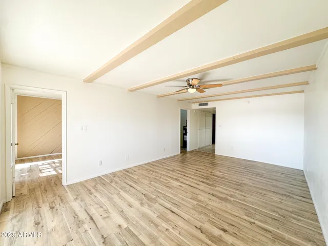 a view of empty room with wooden floor