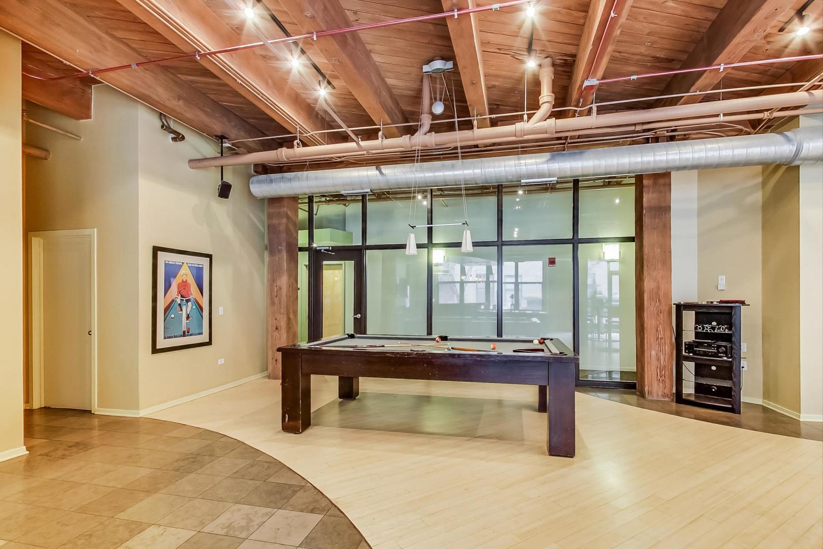 1040 West Adams Street, Unit 222 Chicago, IL 60607 - Photo 16 of 20 a bedroom with a bed and a table