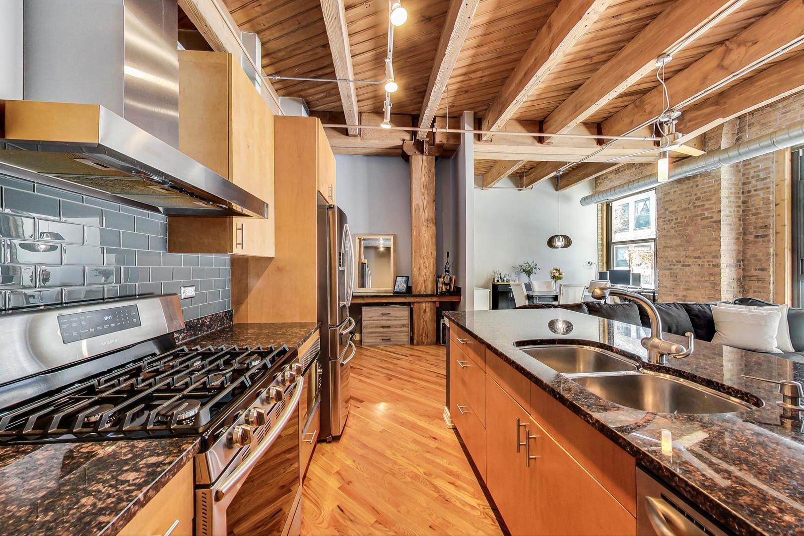 1040 West Adams Street, Unit 222 Chicago, IL 60607 - Photo 8 of 20 a kitchen with granite countertop a sink and a stove