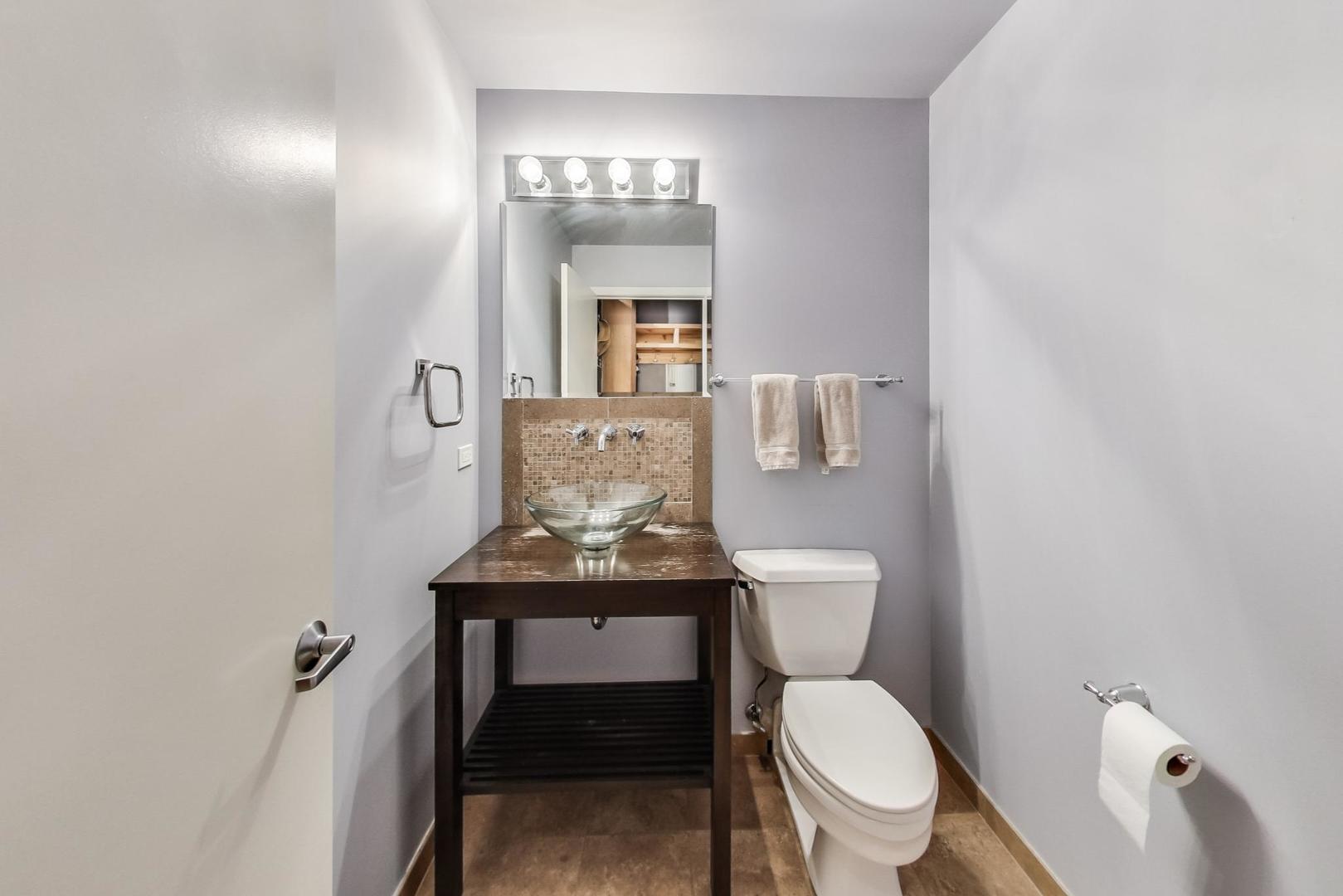 1040 West Adams Street, Unit 222 Chicago, IL 60607 - Photo 9 of 20 a bathroom with a toilet a sink and mirror