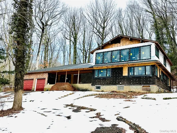 a front view of a house with a yard covered with snow