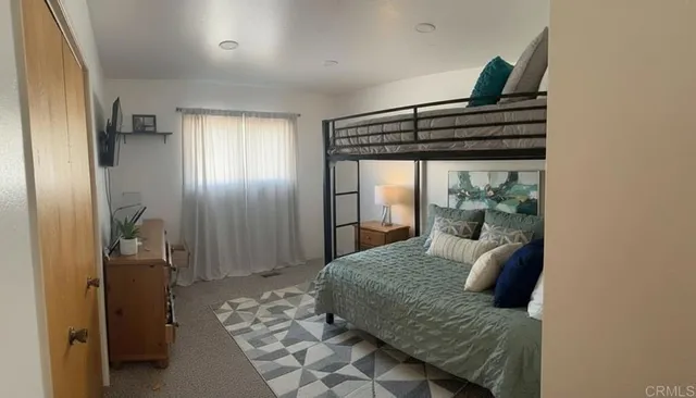 a living room with a bed furniture and a potted plant