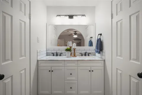 a en suite bathroom with a granite countertop sink and a mirror