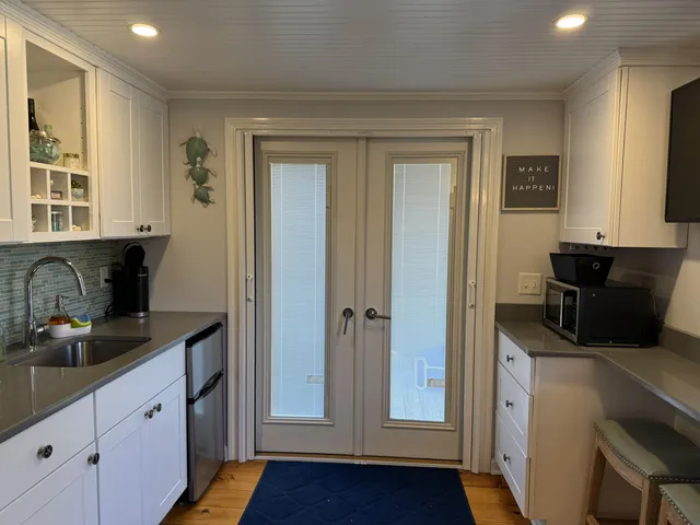 a view of a kitchen with fridge and wooden floor