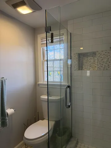 a white toilet sitting next to a bathroom sink