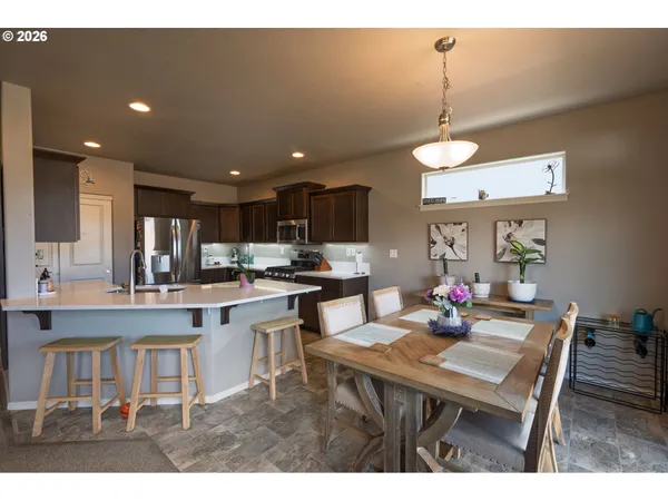 a kitchen with a dining table chairs and white cabinets