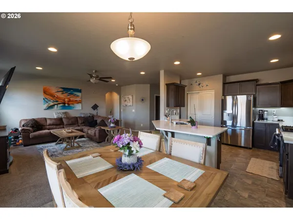 a living room with furniture and a dining table with kitchen view