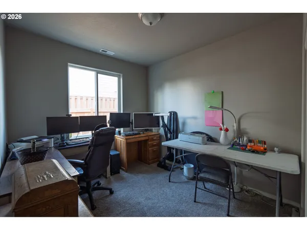 a view of a backyard with table and chairs potted plants and large tree