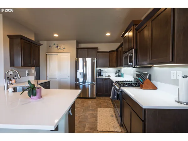 a kitchen with kitchen island a sink stove top oven and refrigerator