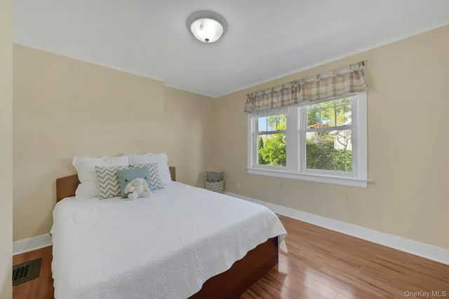 a bedroom with a bed and a wooden floor