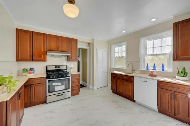 a kitchen with stainless steel appliances granite countertop a stove sink and cabinets