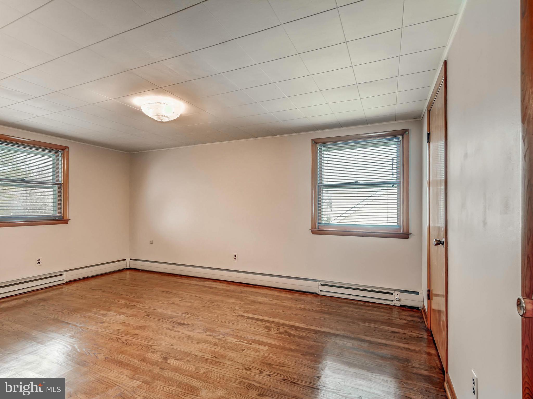 7306 Manchester Road Baltimore, MD 21222 - Photo 16 of 24 an empty room with wooden floor and windows