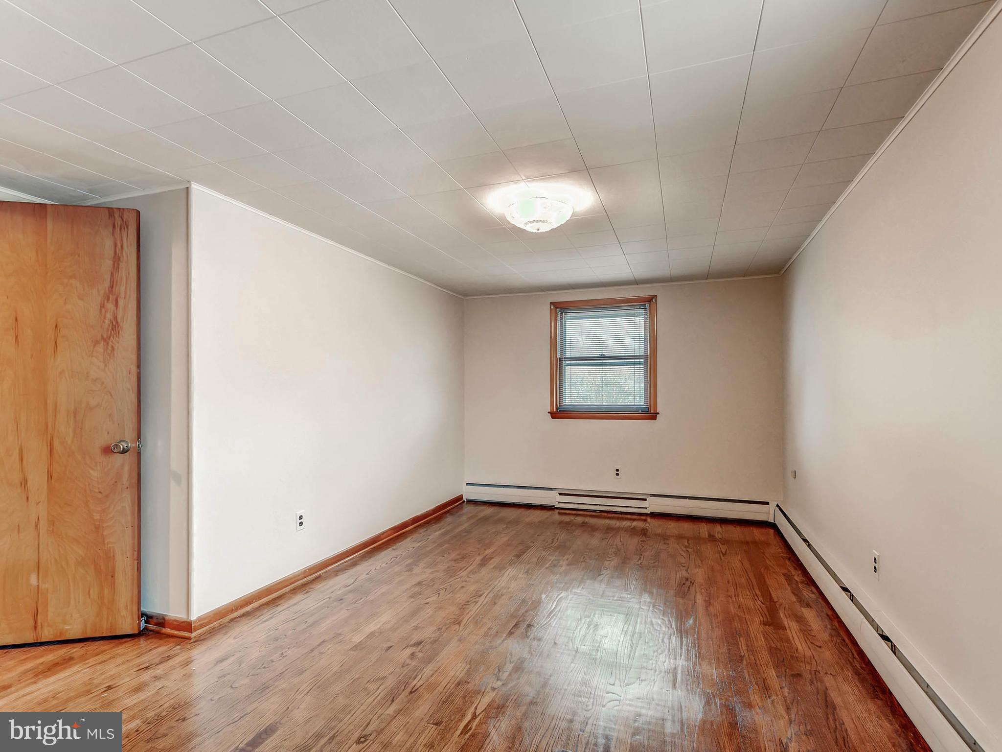 7306 Manchester Road Baltimore, MD 21222 - Photo 17 of 24 an empty room with wooden floor and windows